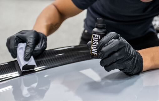 Xpel fusion plus ceramic coating application on a car's body paint with sponge.
